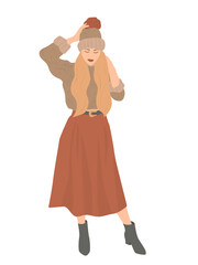 Beautiful portrait of a woman in winter. Smiling girl wearing warm clothes having fun. She is wearing hat, sweater and long skirt isolated on white wall