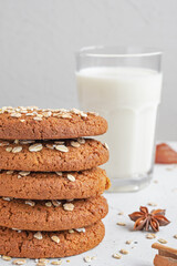 oatmeal cookies and glass of milk on white concrete background