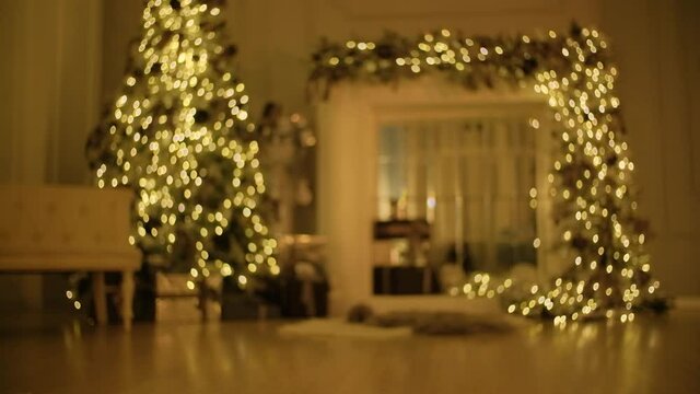 Blurred video of a Christmas tree and fireplace with Christmas lights.