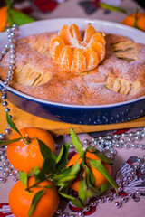 christmas cake with apples and tangerines on the table