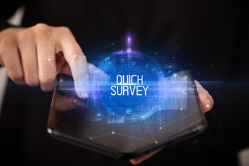 Young man holding a foldable smartphone with QUICK SURVEY inscription, educational concept