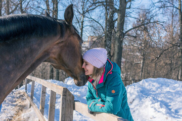 Young woman with a horse in the winter forest