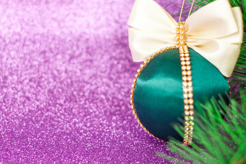 Green Christmas ball in rhinestones for decorating the Christmas tree. Christmas toy. Christmas toy for decorating a Christmas tree on a lilac background. Shining crystals on a green ball.