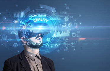 Businessman looking through Virtual Reality glasses with REALITY inscription, innovative technology concept