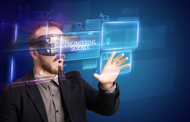 Obraz premium Businessman looking through Virtual Reality glasses with ENGINEERING SCIENCE inscription, new technology concept