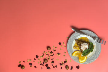 Piece of delicious pumpkin pie with fresh mint leaves, cream, cinnamon, maple syrup and slice of orange on white dish with fork on pink background with copy space. Happy Thanksgiving. Dublin, Ireland