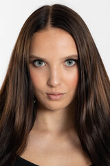 Portrait of a teenage girl with dark and long hair and beautiful makeup. Tanned European female beauty.