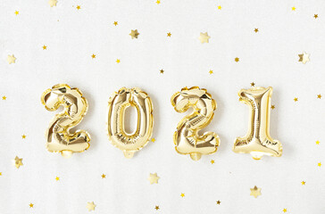 Happy New 2021 Year. Holiday gold metallic balloon numbers 2021 and confetti on silver background.