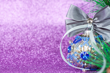 Obraz na płótnie Canvas Beautiful and very shiny bead. Toy for the Christmas tree. Christmas balloon on a purple background. New year greetings, postcards, calendar.