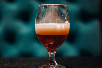 Close up on a glass of amber Pale Ale beer on wooden table in bar with copy space.