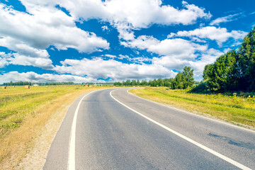 Asphalt road leading into the distance around the bend.