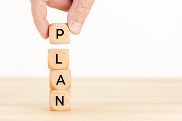 Plan concept. Hand holding a Wooden block with text on table. Copy space