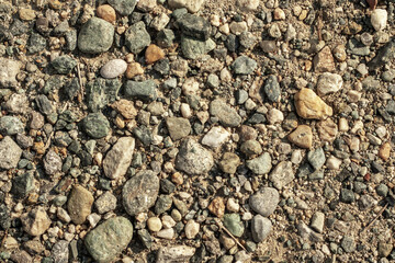 terreno ghiaioso con pietre di varie dimensioni e colori e terra