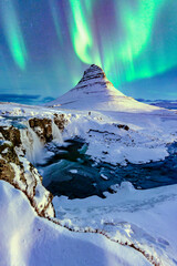 northern lights appear over Mount Kirkjufell in Iceland. - obrazy, fototapety, plakaty