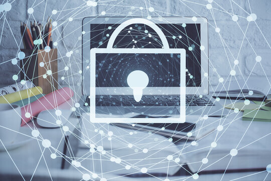 Double exposure of desktop with computer and lock icon hologram. Concept of data safety.
