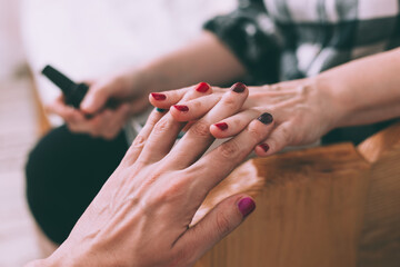 Obraz na płótnie Canvas Man and woman having painted nails, holding hands. Close up shot.