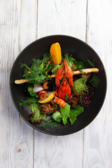Salad with seafood in a dark plate.