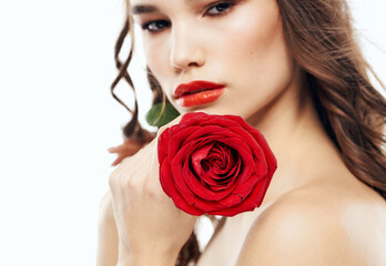 Fototapeta na wymiar Romantic woman with red blossoming flowers near face cropped view of brunette makeup