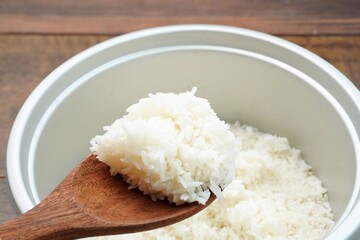 Steamed white rice cooked in a bowl on a wooden table.