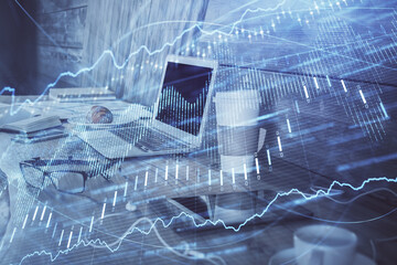 Financial chart drawing and table with computer on background. Double exposure. Concept of...