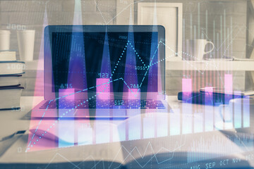 Stock market graph on background with desk and personal computer. Multi exposure. Concept of financial analysis.