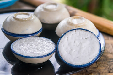 Close up coconut milk custard in small porcelain cup.