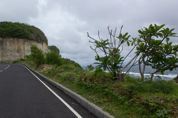 The road to the beach beside there is a rocky hill