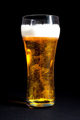  fresh beer in a beautiful tall glass on a black background