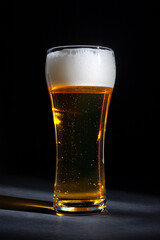  fresh beer in a beautiful tall glass on a black background