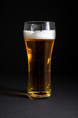  fresh beer in a beautiful tall glass on a black background