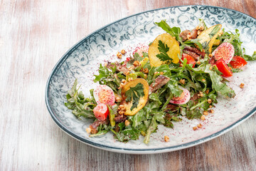 Duck breast salad with potato chips and fresh vegetables. On a decorative plate