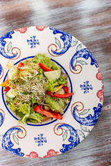 Homemade salad with fresh vegetables and microgreen on a decorative plate