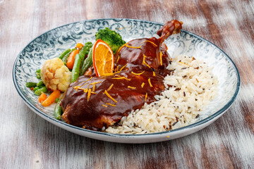 Duck in orange sauce with blanched vegetables and rice