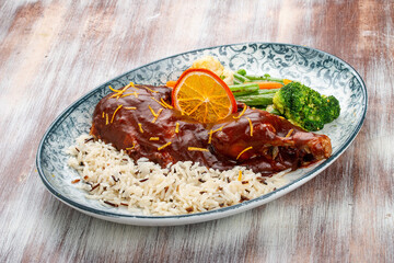 Duck in orange sauce with blanched vegetables and rice
