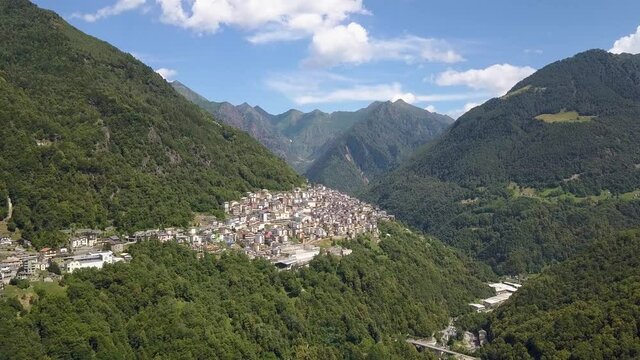 Aerial of a beautiful small village on a lush green mountain, Premana, Italia