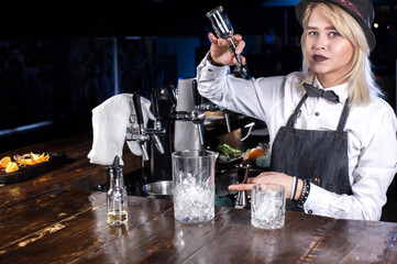 Girl bartender concocts a cocktail on the beerhouse