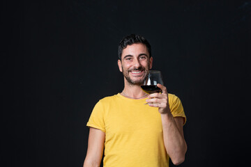Man drinking red wine on black background