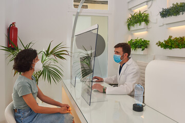 Doctor attends to his patient, they have the mask on and there i