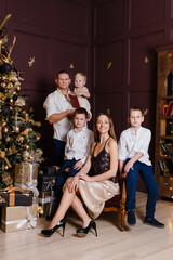 stylish beautiful family in smart clothes at the New Year photo shoot. dark studio design.