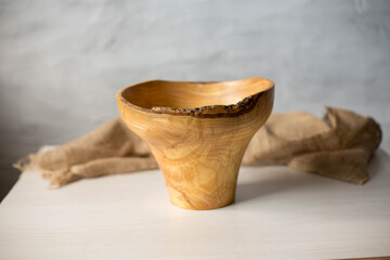 Wooden plate on a white table. National dishes. Crockery made from natural materials. Wood texture