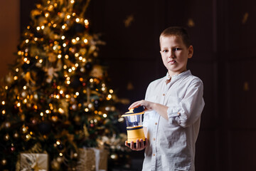 eight-year-old boy in white shirt holds a christmas light