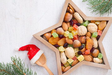 Christmas nuts and dried fruit mix in star-shaped bowl on white background assortment of delicacies