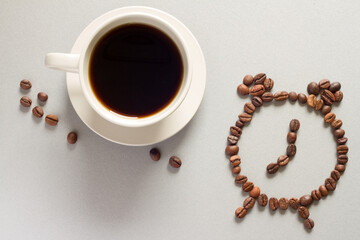 Coffee time. Morning coffee cup and alarm clock with coffee beans, abstract
