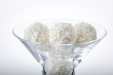 truffles white chocolate  covered with coconut flakes on white background