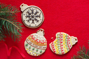 Hand decorated christmas cookies in shape of baubles on red background