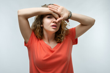 Fototapeta premium Portrait of frightened young woman covering her eyes with hands. Human emotions, facial expression concept