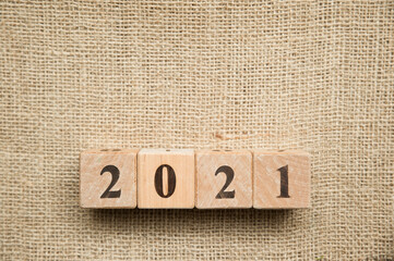 Happy New Year 2021 Christmas and New Year background. Symbol from number. Wooden cubes on canvas.