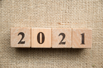 Happy New Year 2021 Christmas and New Year background. Symbol from number. Wooden cubes on canvas.