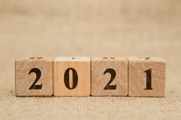 Happy New Year 2021 Christmas and New Year background. Symbol from number. Wooden cubes on canvas.