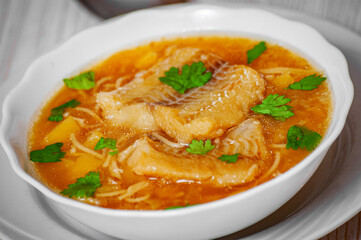 Fish soup with potato and noodles in bowl